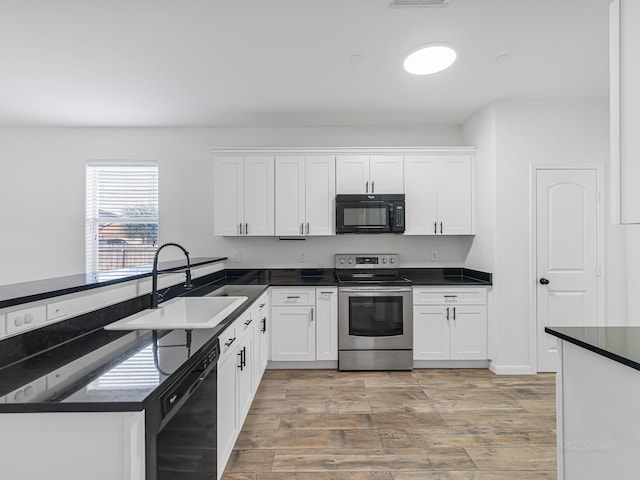 kitchen featuring kitchen peninsula, sink, white cabinetry, and black appliances