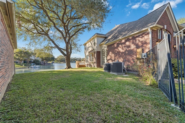 view of yard with a water view and central AC