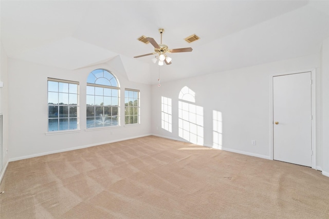 carpeted empty room featuring a water view, ceiling fan, and lofted ceiling