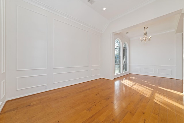 unfurnished room featuring crown molding, hardwood / wood-style floors, and an inviting chandelier