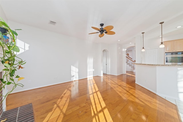 unfurnished living room with ceiling fan and light hardwood / wood-style flooring