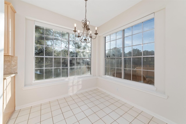 unfurnished dining area with plenty of natural light, light tile patterned floors, and a chandelier