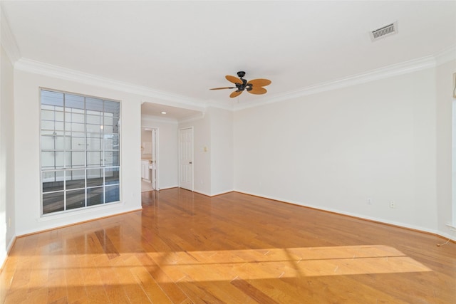 empty room with wood-type flooring, ceiling fan, and crown molding