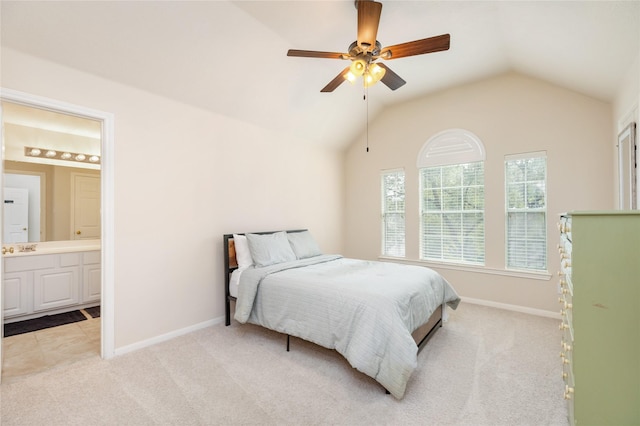 carpeted bedroom with ensuite bathroom, vaulted ceiling, and ceiling fan