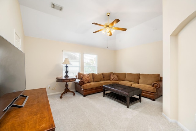 living room featuring ceiling fan, vaulted ceiling, and light carpet