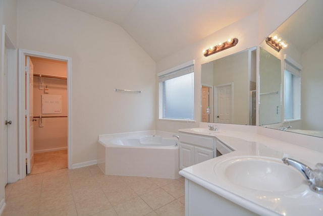 bathroom featuring tile patterned floors, a bathing tub, vanity, and lofted ceiling