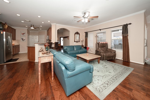 living room featuring dark hardwood / wood-style flooring, ceiling fan, and crown molding