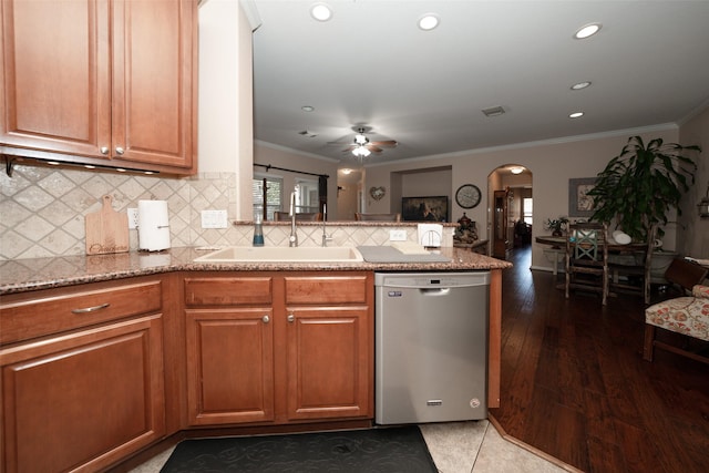 kitchen featuring ceiling fan, sink, stainless steel dishwasher, decorative backsplash, and ornamental molding