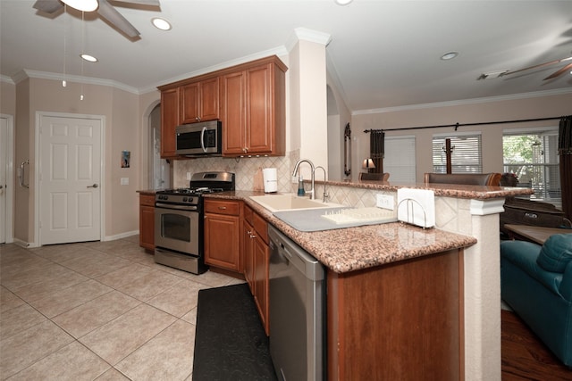 kitchen featuring kitchen peninsula, ornamental molding, stainless steel appliances, sink, and light tile patterned flooring