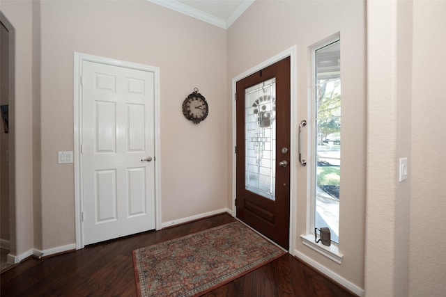 foyer entrance with ornamental molding and dark wood-type flooring