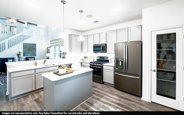 kitchen featuring gray cabinetry, a center island, pendant lighting, and appliances with stainless steel finishes