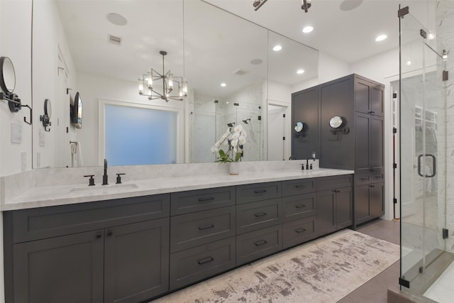 bathroom featuring vanity, a shower with shower door, and a chandelier