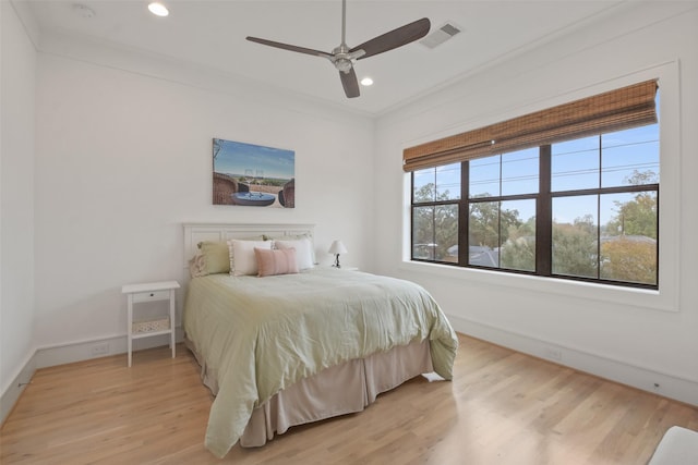 bedroom with ceiling fan, light wood-type flooring, and multiple windows