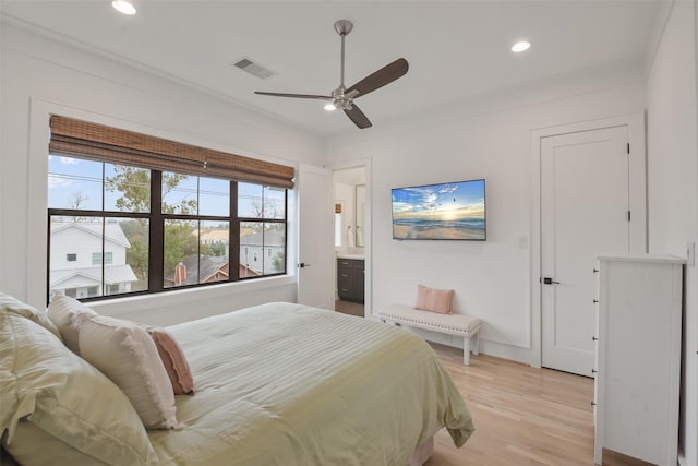 bedroom featuring ensuite bath, ceiling fan, ornamental molding, and light wood-type flooring