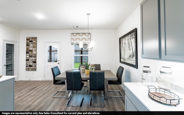 dining space featuring hardwood / wood-style floors and a chandelier