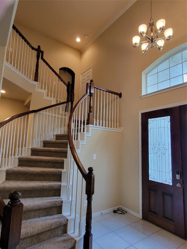 tiled foyer entrance with a towering ceiling and an inviting chandelier