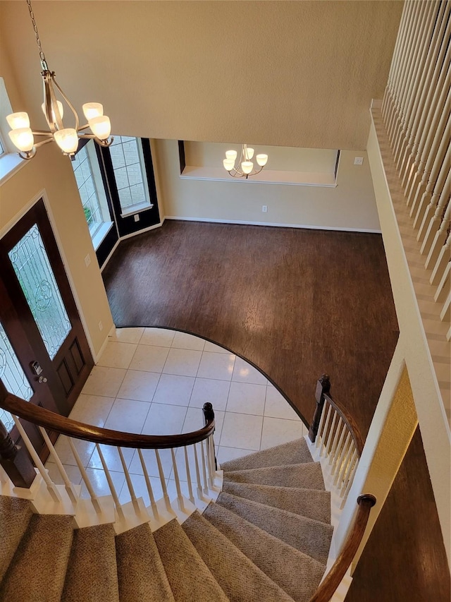 staircase with tile patterned flooring and a notable chandelier