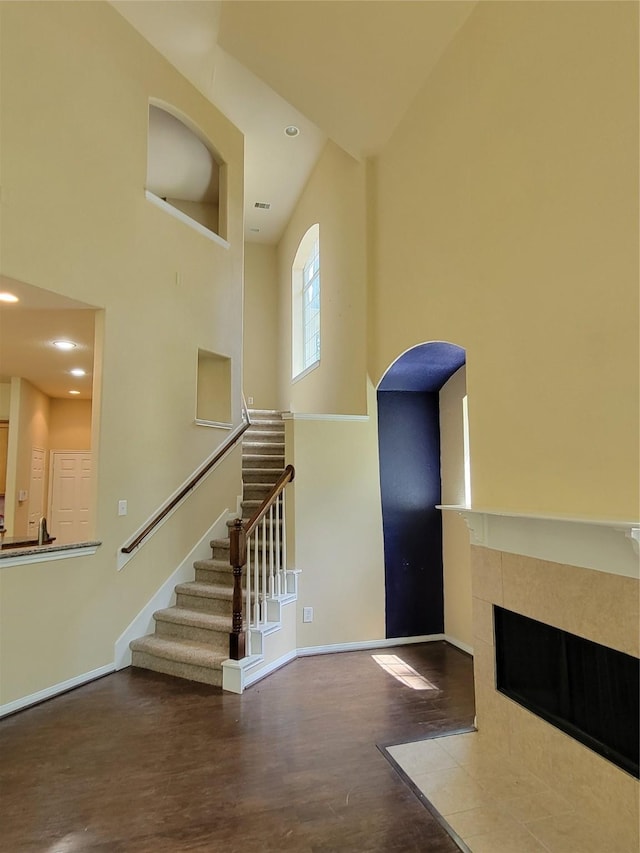 interior space with a tile fireplace and a towering ceiling