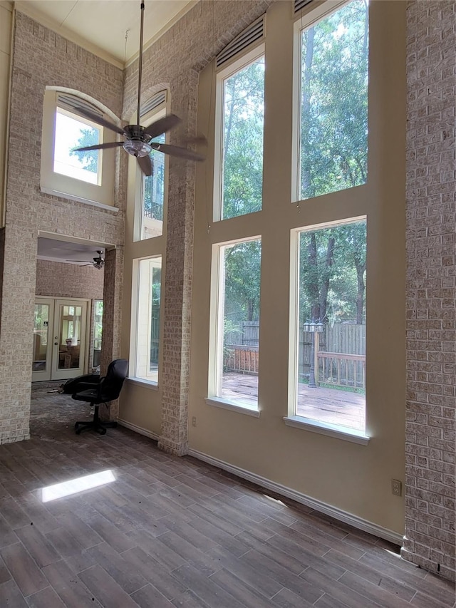 unfurnished living room featuring a high ceiling and hardwood / wood-style flooring