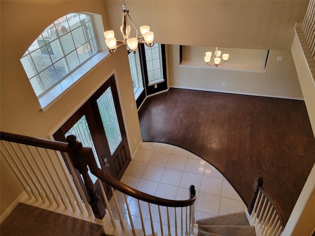 foyer with tile patterned flooring, a chandelier, and french doors