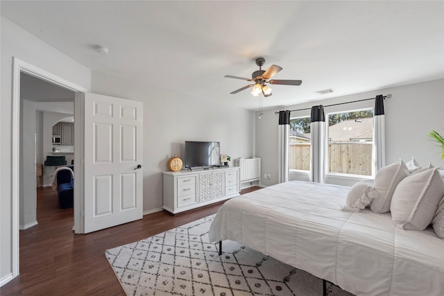 bedroom featuring radiator heating unit, ceiling fan, and dark wood-type flooring