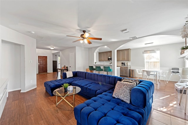 living room with wood-type flooring and ceiling fan