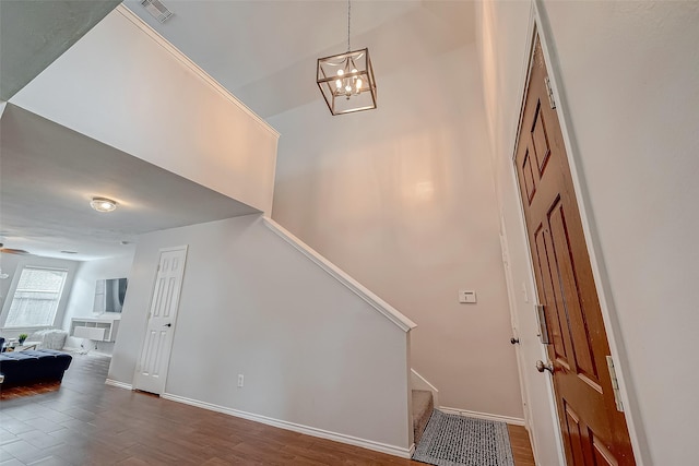 stairway featuring ceiling fan with notable chandelier and hardwood / wood-style floors