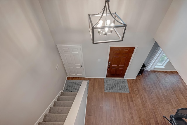 entrance foyer with an inviting chandelier and hardwood / wood-style floors