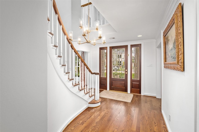 entrance foyer featuring crown molding, dark hardwood / wood-style floors, and a notable chandelier