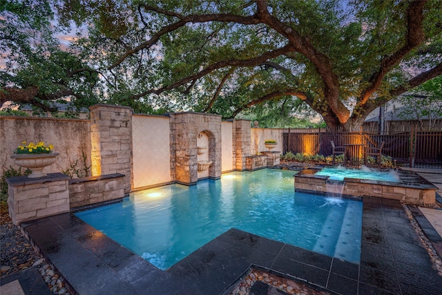 pool at dusk with pool water feature