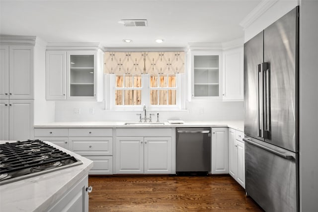 kitchen with dark hardwood / wood-style flooring, light stone counters, stainless steel appliances, sink, and white cabinets