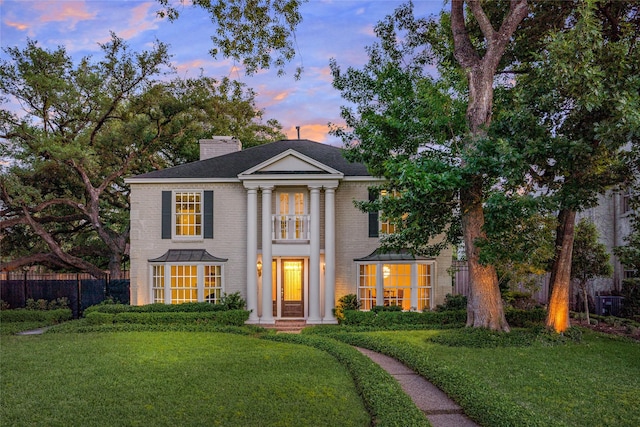 greek revival house featuring a lawn