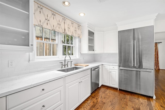 kitchen featuring dark wood-type flooring, white cabinets, sink, light stone countertops, and appliances with stainless steel finishes