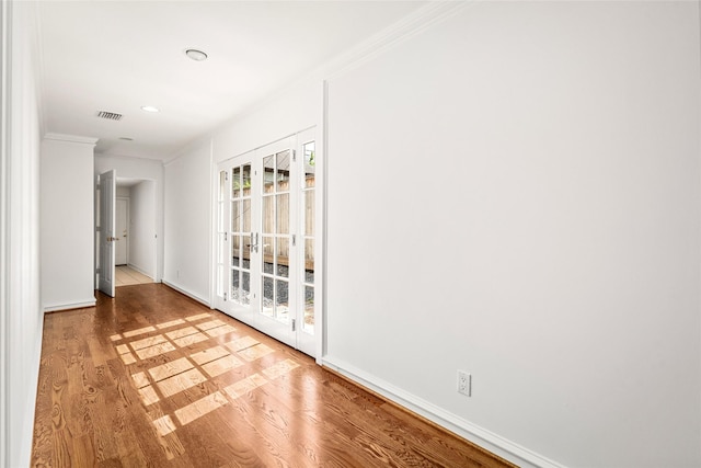 empty room with hardwood / wood-style flooring and ornamental molding