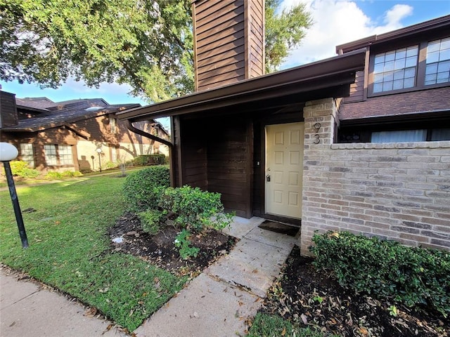 view of exterior entry featuring a yard