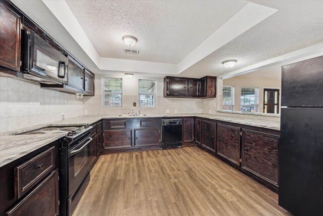 kitchen featuring black appliances, light hardwood / wood-style floors, sink, and a textured ceiling