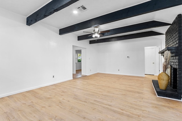 unfurnished living room with beamed ceiling, light wood-type flooring, a brick fireplace, and ceiling fan