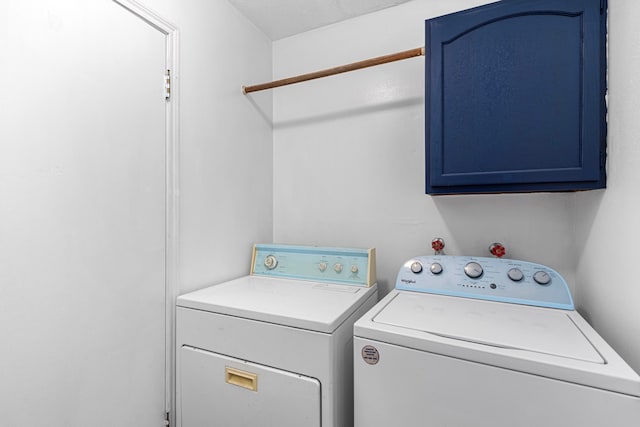 laundry area featuring washer and dryer and cabinets