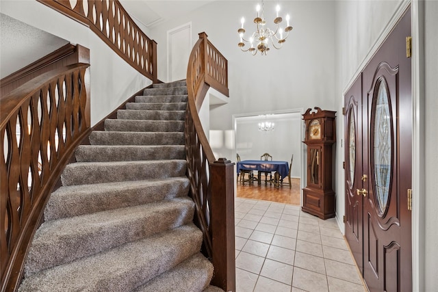 entryway featuring a towering ceiling, a chandelier, and light tile patterned floors