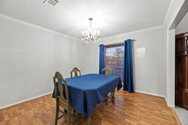 dining room with ornamental molding, a textured ceiling, a notable chandelier, and light hardwood / wood-style floors