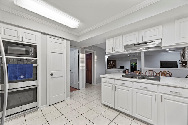 kitchen featuring light tile patterned floors, crown molding, white cabinets, appliances with stainless steel finishes, and ceiling fan