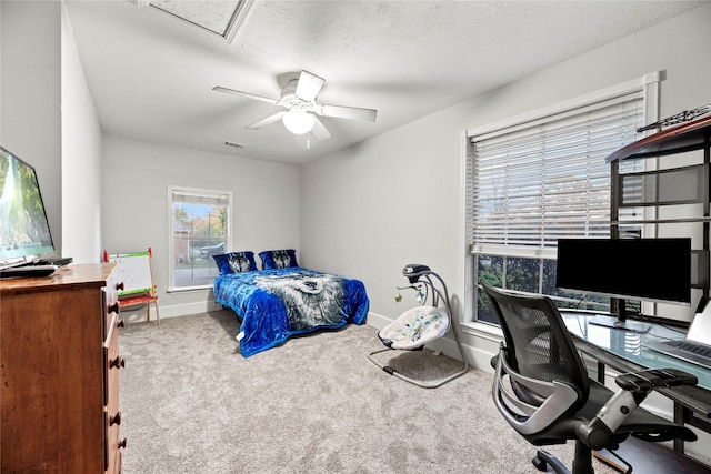 bedroom with ceiling fan, carpet floors, and a textured ceiling