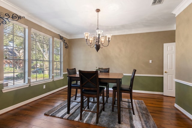 dining room featuring crown molding, a chandelier, and dark hardwood / wood-style floors