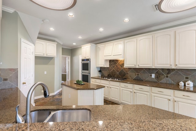 kitchen featuring dark stone countertops, sink, a kitchen island, and appliances with stainless steel finishes