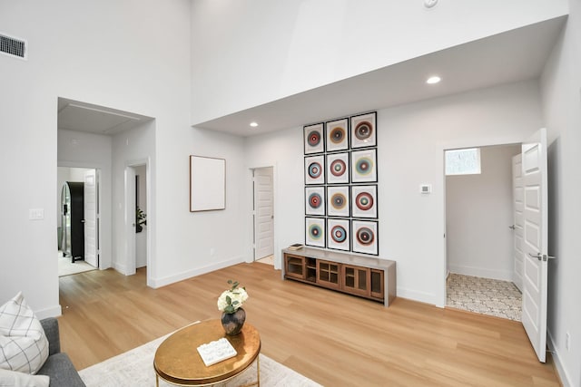 living room with hardwood / wood-style flooring and a towering ceiling