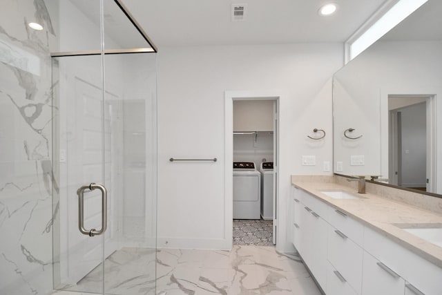 bathroom featuring washer and dryer, vanity, and an enclosed shower