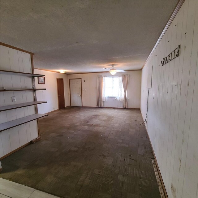 empty room with hardwood / wood-style floors, a textured ceiling, and wooden walls