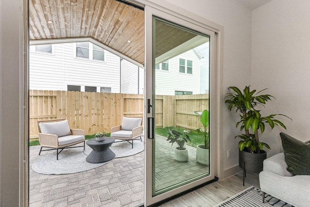 doorway featuring wooden walls, hardwood / wood-style floors, and wood ceiling