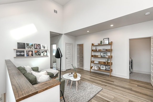 living room featuring wood-type flooring and a towering ceiling