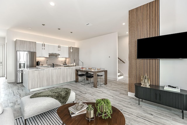 living room with sink and light wood-type flooring